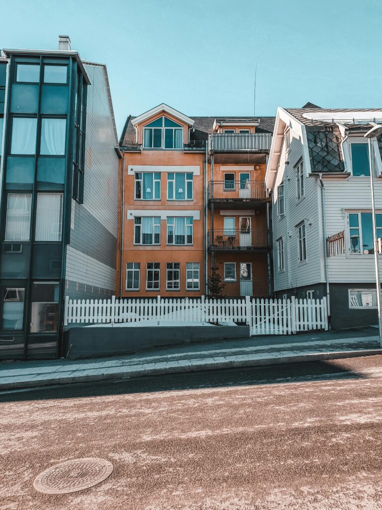 A vibrant street view featuring diverse residential architecture and a clear blue sky.